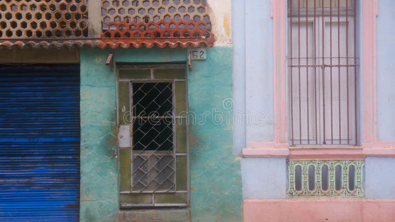 Colorful building front view of windows and door from the streets of Havana, Cuba. Featuring layers of architectural styles in cobalt blue, olive green, aqua, orange, pink and blue. Taken December 2015. Colorful building front view of windows and door from the streets of Havana, Cuba. Featuring layers of architectural styles in cobalt blue, olive green, aqua, orange, pink and blue. Taken December 2015.