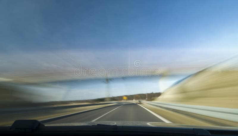 Una vista attraverso il parabrezza di un'automobile di accelerazione, il motion blur.