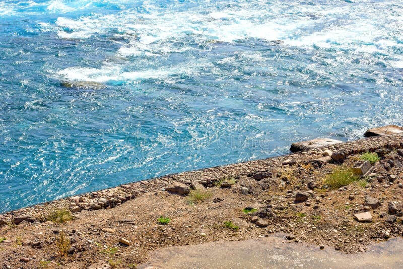 Fast clear blue mountain river water stream with waves flowing near the rocky shore in summer. royalty free stock photos Fast clear blue mountain river water stream with waves flowing near the rocky shore in summer. royalty free stock photos