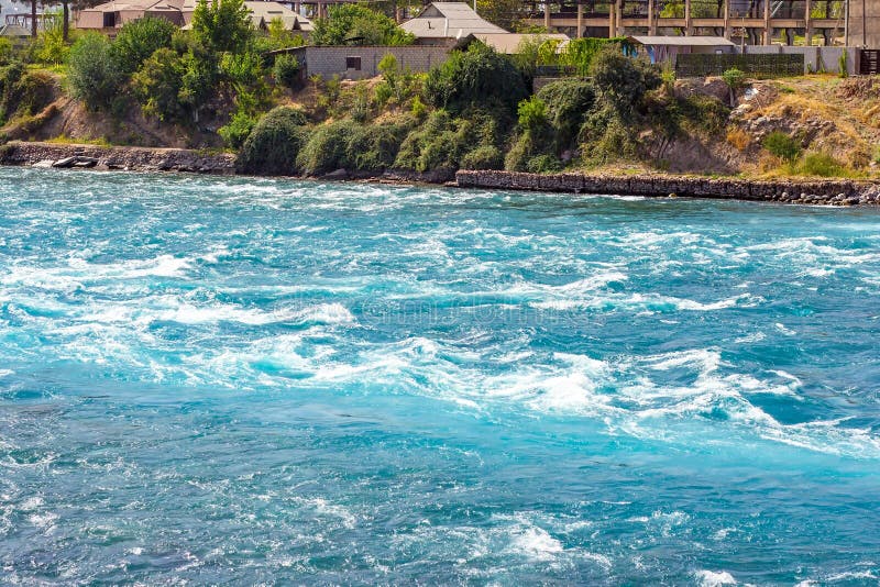 Fast clear blue mountain river water stream with waves flowing near the rocky shore in summer. royalty free stock photography Fast clear blue mountain river water stream with waves flowing near the rocky shore in summer. royalty free stock photography