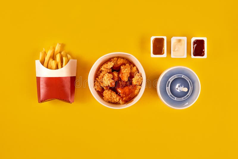 Fast food dish on yellow background. Fast food set fried chicken and french fries. Take away fast food.