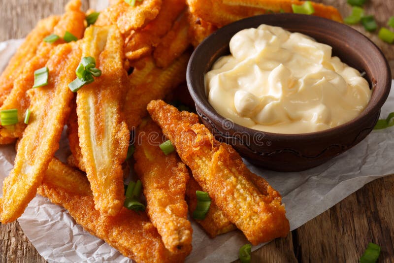 Fast food: fried baby corn with green onions and sauce close-up. horizontal