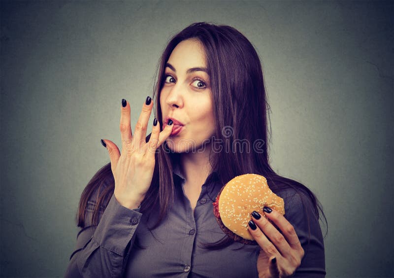 Fast food jest mój faworytem Kobieta je hamburger cieszy się smak