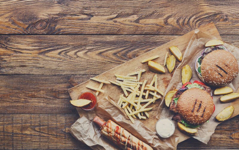 Fast food top view on wood. Hamburger, hotdog and fries stock photography Fast food top view on wood. Hamburger, hotdog and fries stock photography