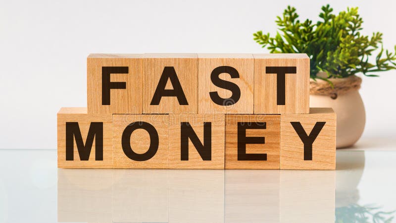 FAST MONEY-motiveringstext om affärskoncept för träblock, vit bakgrund Främre vybegrepp, blomma i bakgrunden fotografering för bildbyråer
