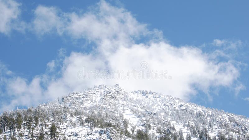 Clouds over snowy mountain stock video footage