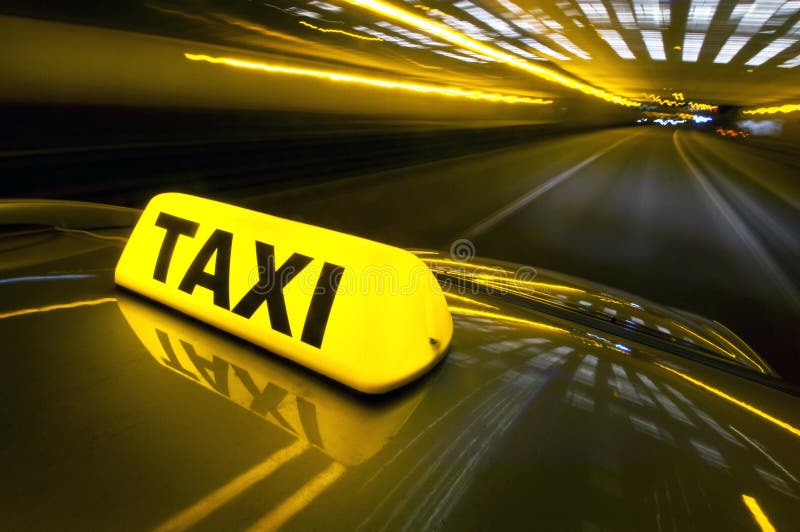 Una cabina ad alta velocità su un'autostrada in un'area urbana con l'illuminato taxi segno sulla cima del tetto.