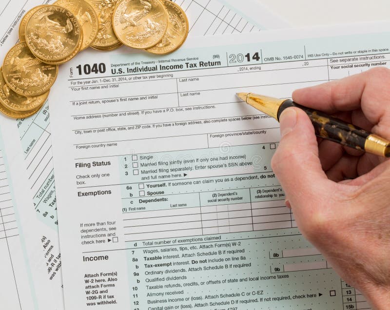 Fasta guld- mynt på 2014 form 1040 arkivbild Fasta guld- mynt på 2014 form 1040 arkivbild