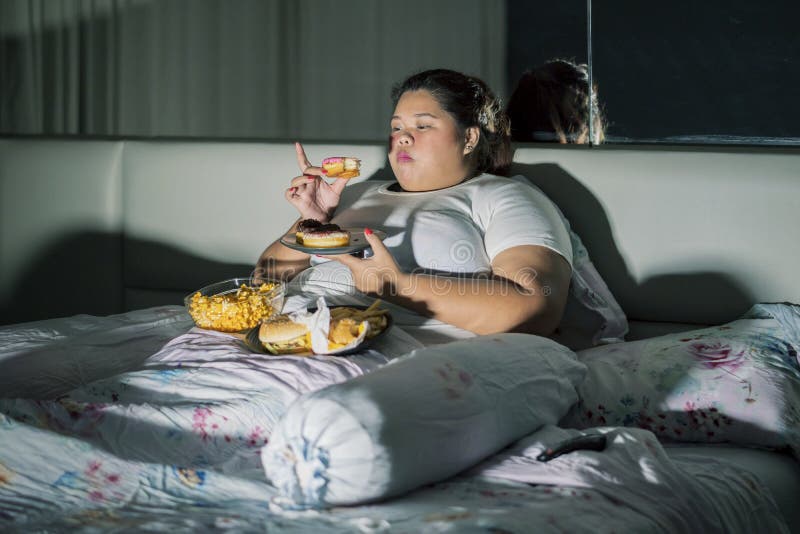 fat-asian-woman-eating-doughnuts-watching-tv-fat-asian-woman-eating-doughnuts-watching-television-entertainments-166805260.jpg