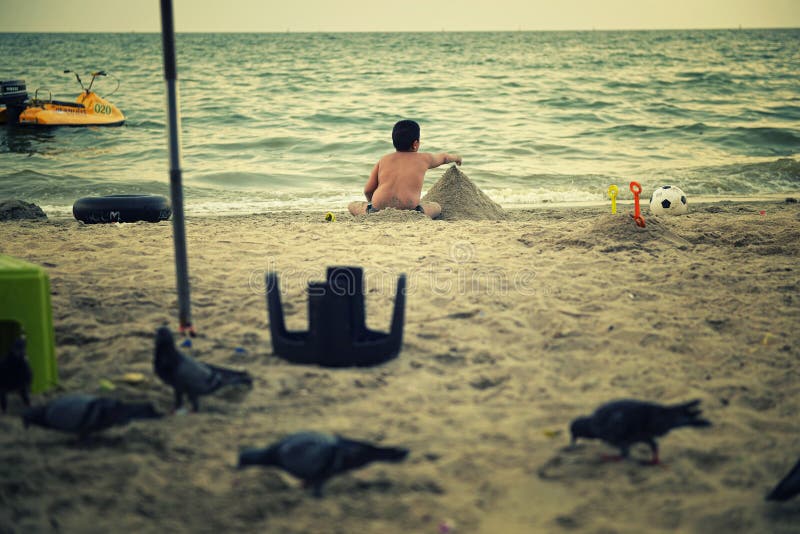 Fat boy playing on the beach