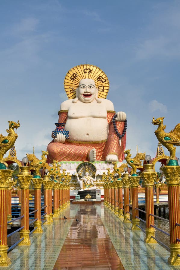Fat laughing Buddha over blue sky