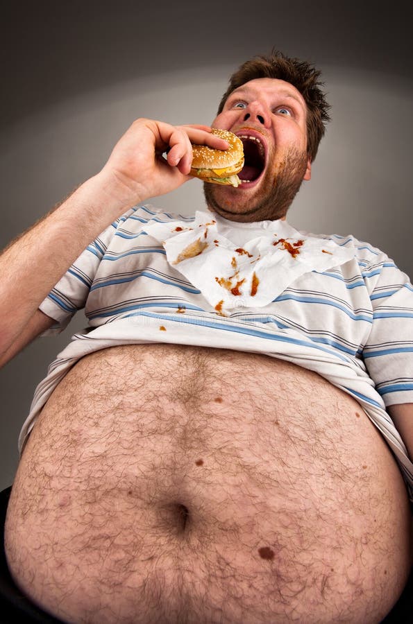 Fat man eating burger stock photo.
