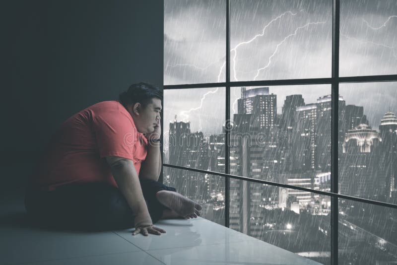 Man looking through window at cityscape stock photo - OFFSET