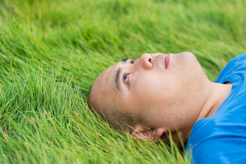 Fat Man Lying on the Green Grass with a stress thoughts