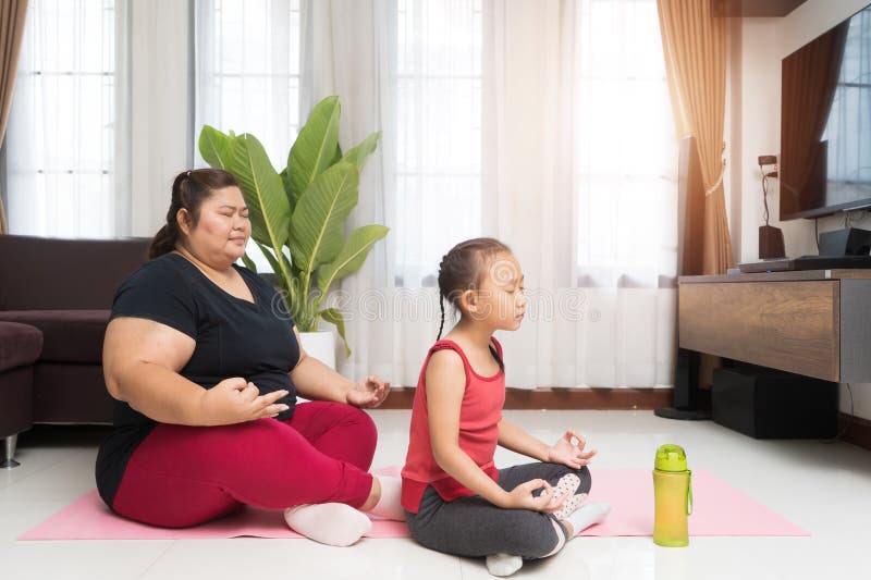 Fat woman asian with little girl exercising at home