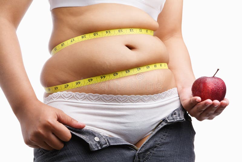 Fat woman with unzip jeans holding apple stock image Fat woman with unzip jeans holding apple stock image
