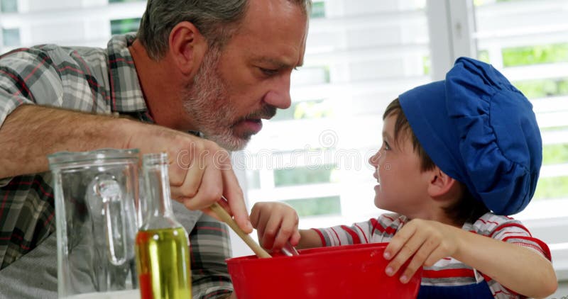 Father and boy mixing dough in bowl