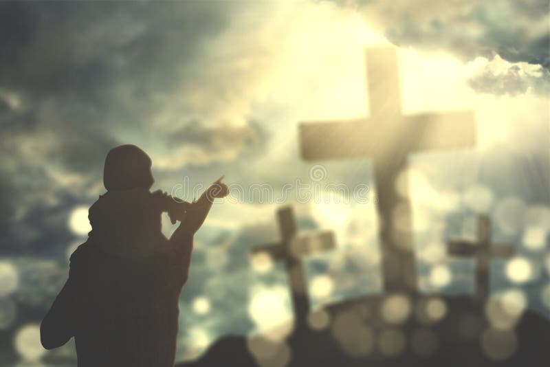 Portrait of father piggybacking his child while looking at three crucifixes under sunbeam. Portrait of father piggybacking his child while looking at three crucifixes under sunbeam