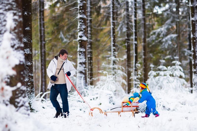 Father and kids enjoy a sleigh ride in winter forest. Baby boy and toddler girl sled in snowy park. Dad pulling children on sledge. Parent and child sledding. Family outdoor fun on Christmas vacation. Father and kids enjoy a sleigh ride in winter forest. Baby boy and toddler girl sled in snowy park. Dad pulling children on sledge. Parent and child sledding. Family outdoor fun on Christmas vacation