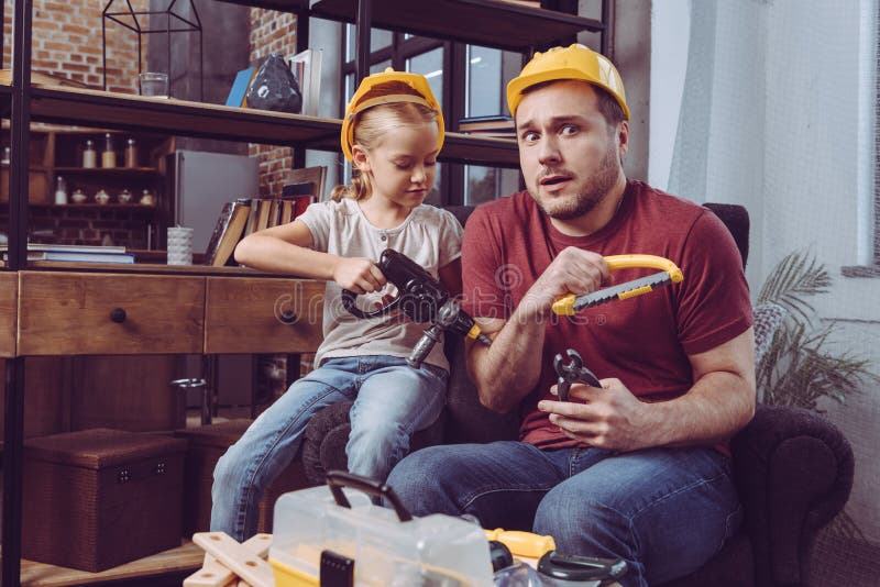 Father and daughter having fun while making wooden frame royalty free stock photography Father and daughter having fun while making wooden frame royalty free stock photography
