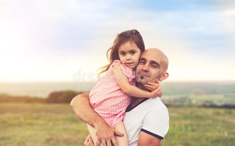 Father and daughter hugging on summer sunset