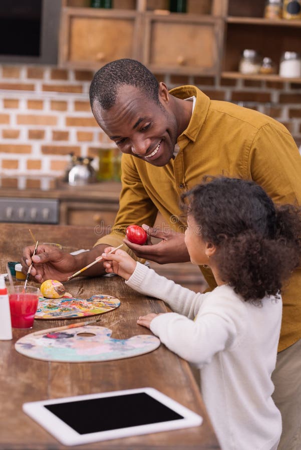 Father and daughter painting easter eggs