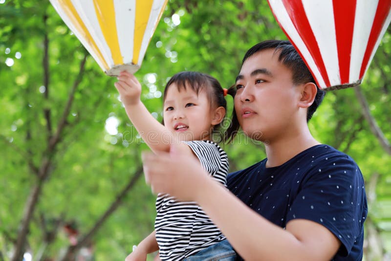 Father and daughter play and have fun in a park at summer sunny day happy child in nature stock photos Father and daughter play and have fun in a park at summer sunny day happy child in nature stock photos