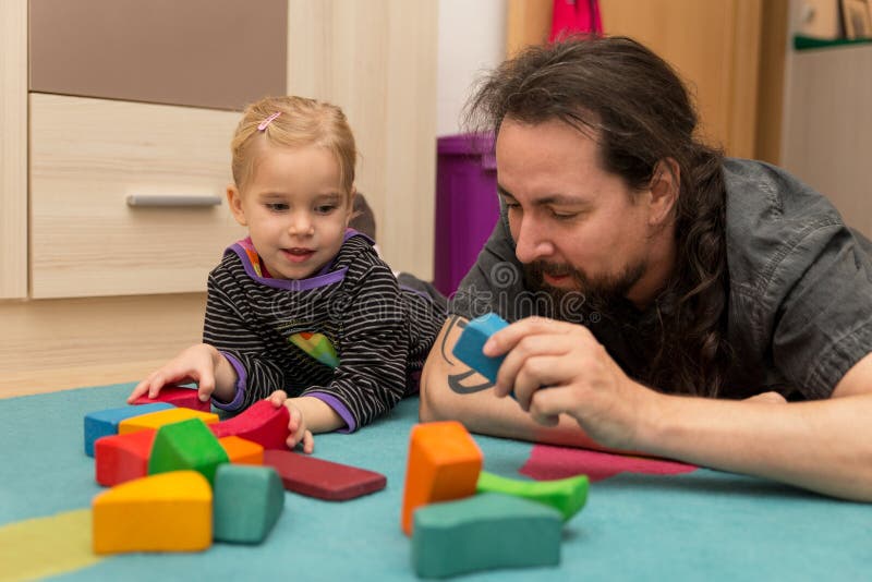 Father and daughter playing with bricks stock photos Father and daughter playing with bricks stock photos
