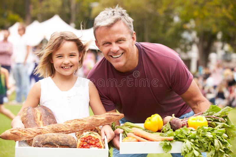 Father And Daughter With Produce From Outdoor Farmers Market