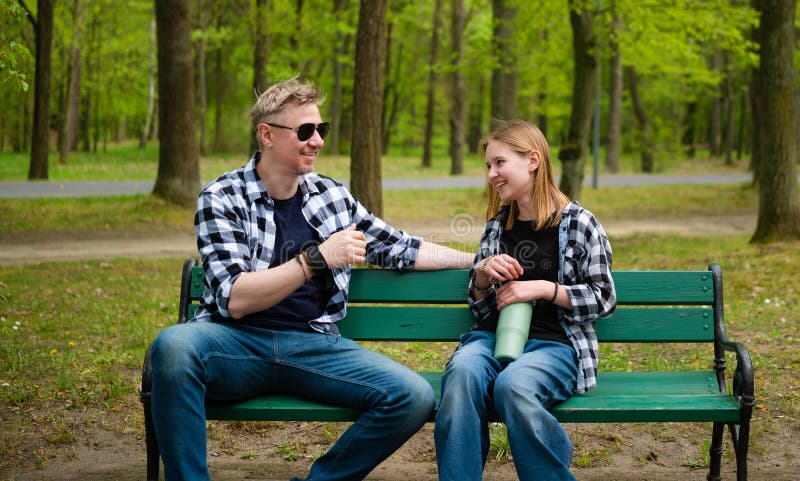 Father And Daughter Sitting On A Bench And Talking In Summer Park. Father daughter listening stock images, royalty-free photos and pictures