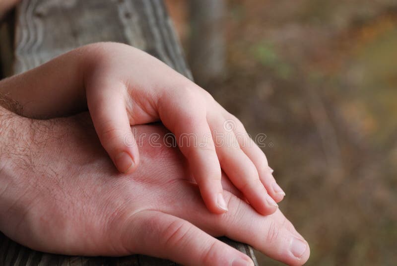 Father and daughter touching hands