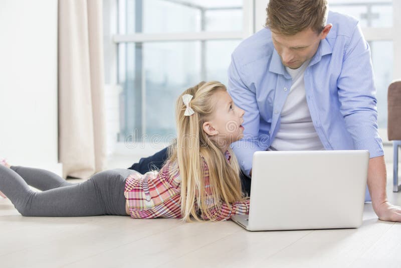 Happy Father Showing Something To Children on Laptop at Home Stock