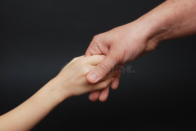 Father giving Hand to a Child. Parental Relationshipp, closeup. Isoalted on Black Background. stock images Father giving Hand to a Child. Parental Relationshipp, closeup. Isoalted on Black Background. stock images