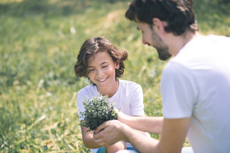 Father giving the plant to his son, the boy smiling royalty free stock photography