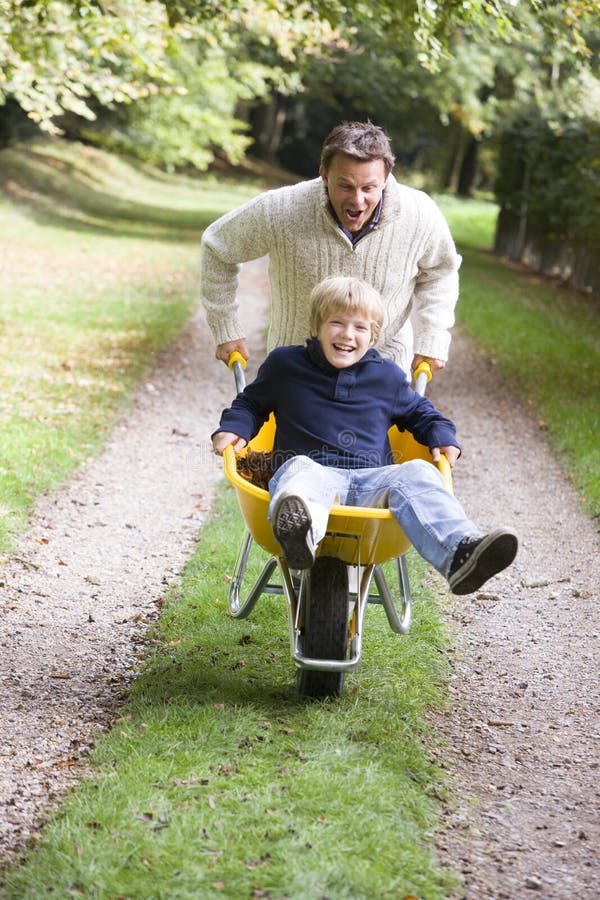 Father giving son ride in wheelbarrow