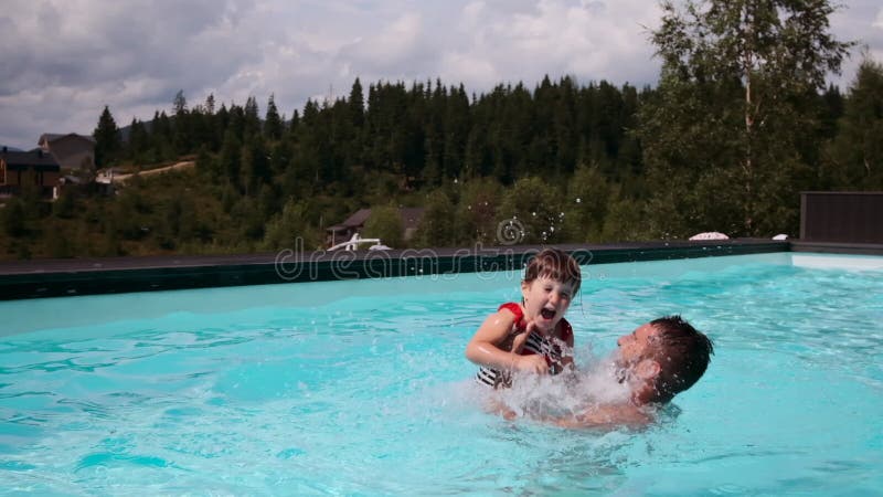 Father playing with daughter in swimming pool