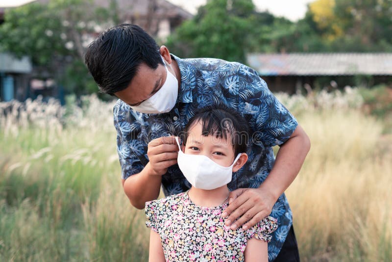 Father help his daughter wearing medical mask for protect covid 19 or corona virus.Vintage style royalty free stock photography Father help his daughter wearing medical mask for protect covid 19 or corona virus.Vintage style royalty free stock photography