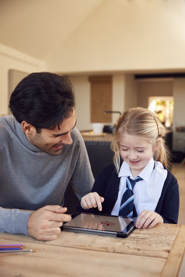 Father Helping Son and Daughter Wearing School Uniform with Homework at