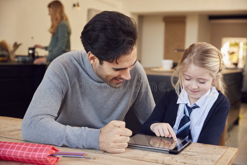 Father Helping Son and Daughter Wearing School Uniform with Homework at