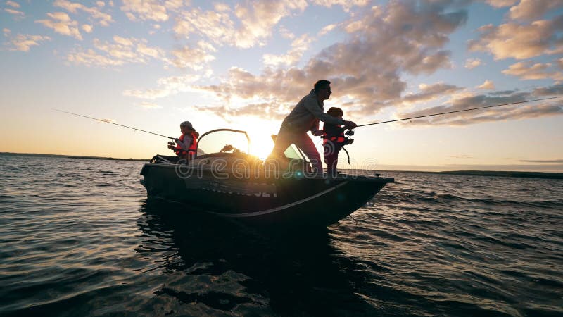 A Father is Helping His Kids with Fishing from a Boat Stock Video