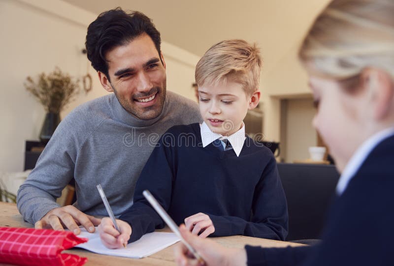 Father Helping Son and Daughter Wearing School Uniform with Homework at