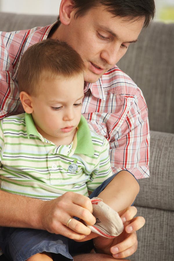 Father helping son putting on socks royalty free stock image Father helping son putting on socks royalty free stock image