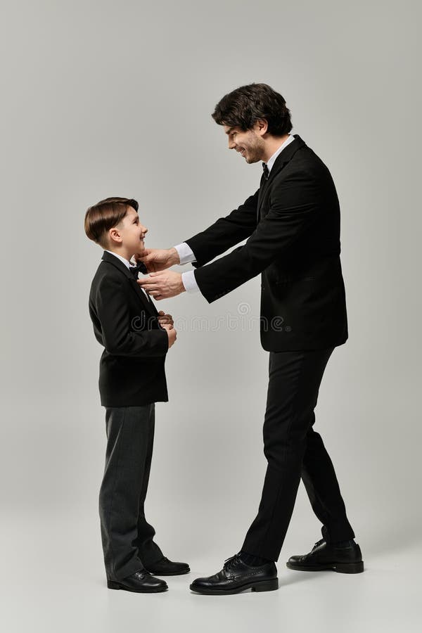 A father helps his son put stock photo. Image of fashion 332625744
