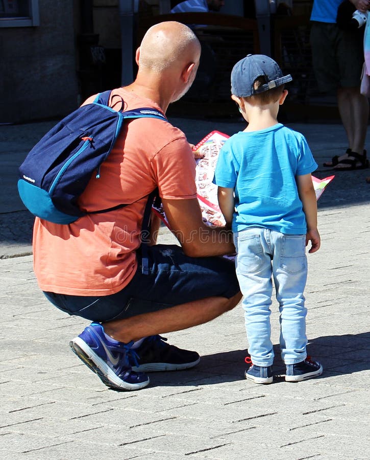 The father and his little son are watching the map royalty free stock images The father and his little son are watching the map royalty free stock images