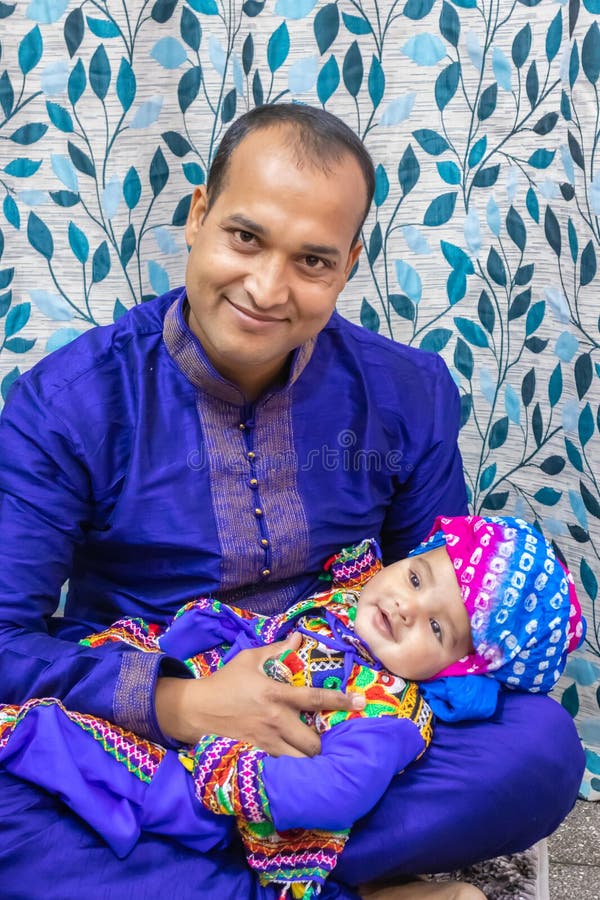 Father Holding Baby Boy at Annaprashana Occasion from Flat Angle Stock