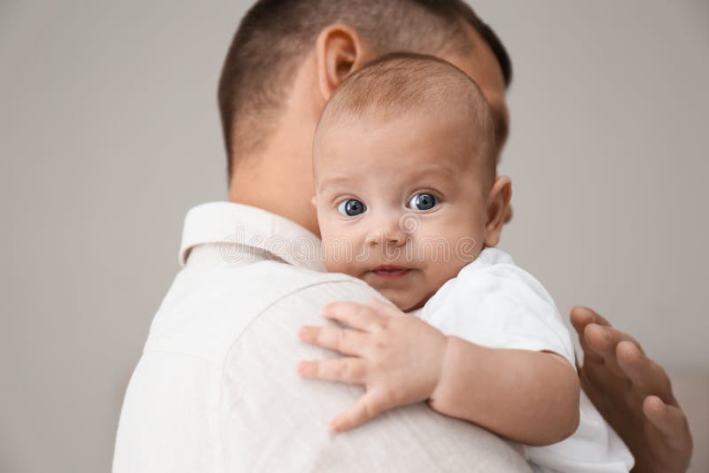 Father Holding His Newborn Baby, Closeup View on Feet. Lovely Family