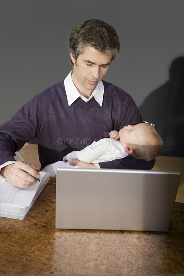 Father holding his son and working stock photos Father holding his son and working stock photos