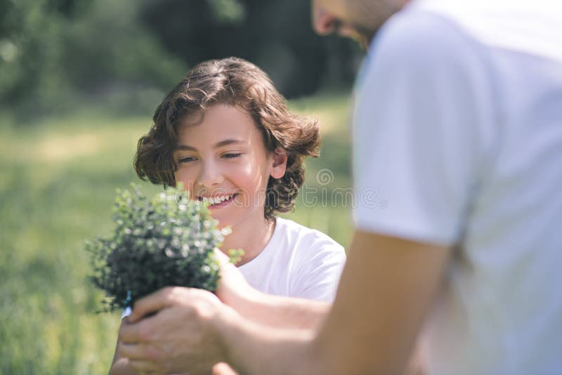 Father holding the plant and showing it to his son stock photography