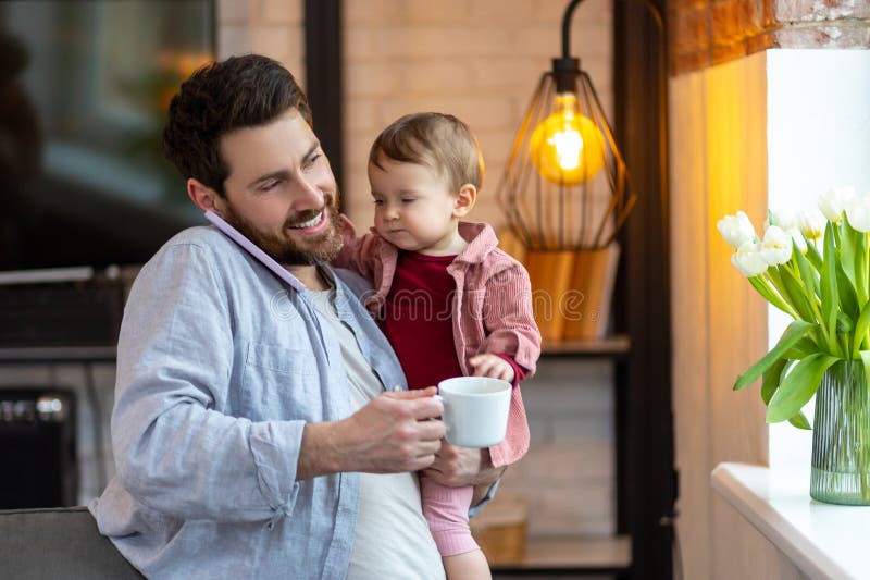 https://thumbs.dreamstime.com/b/father-little-baby-boy-calling-smartphone-home-drinking-coffee-happy-multitasking-277670071.jpg