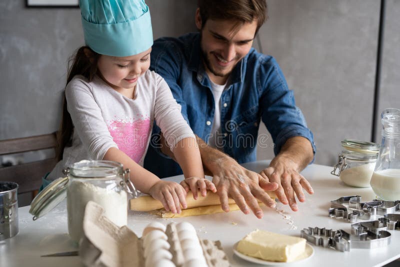 Father and little daughter baking pastries. Family having fun in kitchen and getting ready for a party. royalty free stock photo Father and little daughter baking pastries. Family having fun in kitchen and getting ready for a party. royalty free stock photo